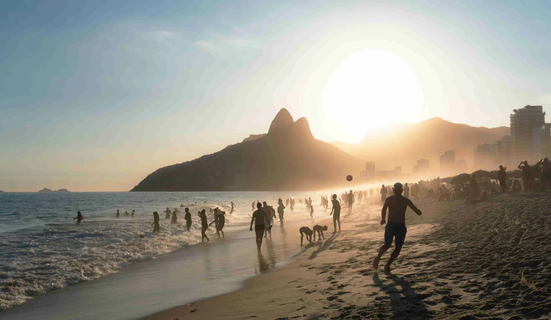 a-crowded-beach-with-a-city-in-the-background
